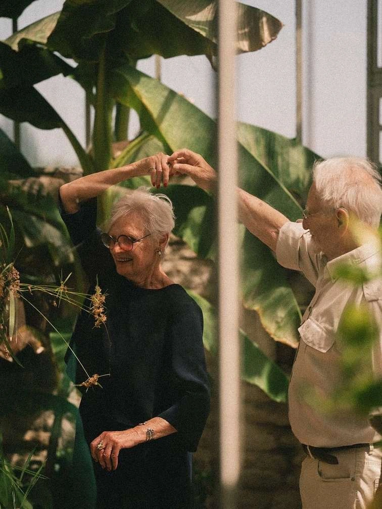 Dos personas bailando entre plantas · imagen de referencia de marca